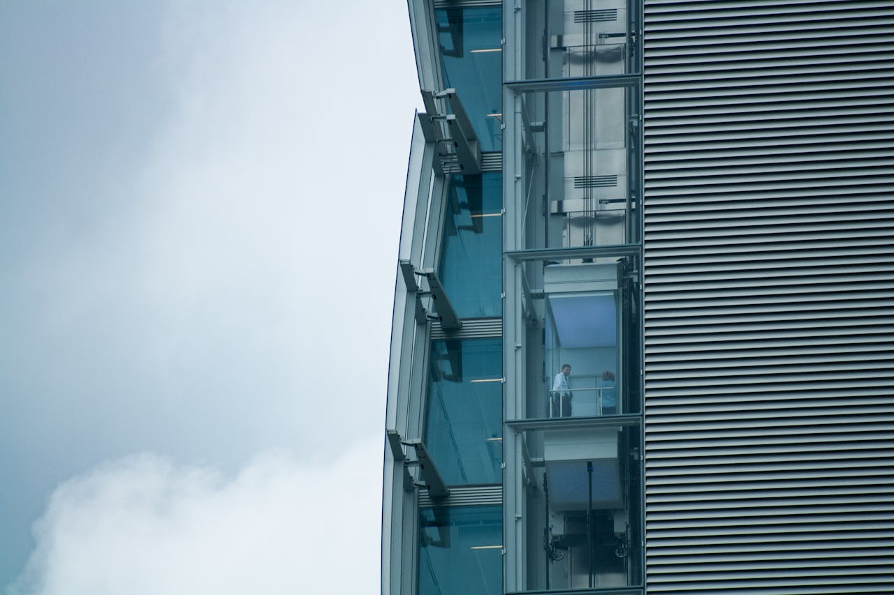 About Close-up of a modern building with glass elevators and steel facade in Milano, Italy.